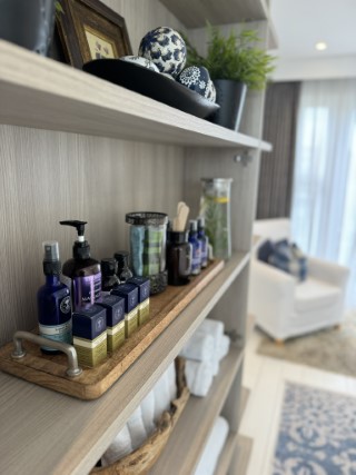 Aromatherapy product neatly displayed on a wooden trade.  Stacks of clean white towels underneath.